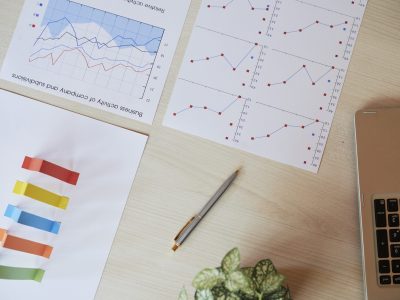 Various charts and graphs on table of financial analyst, view from above